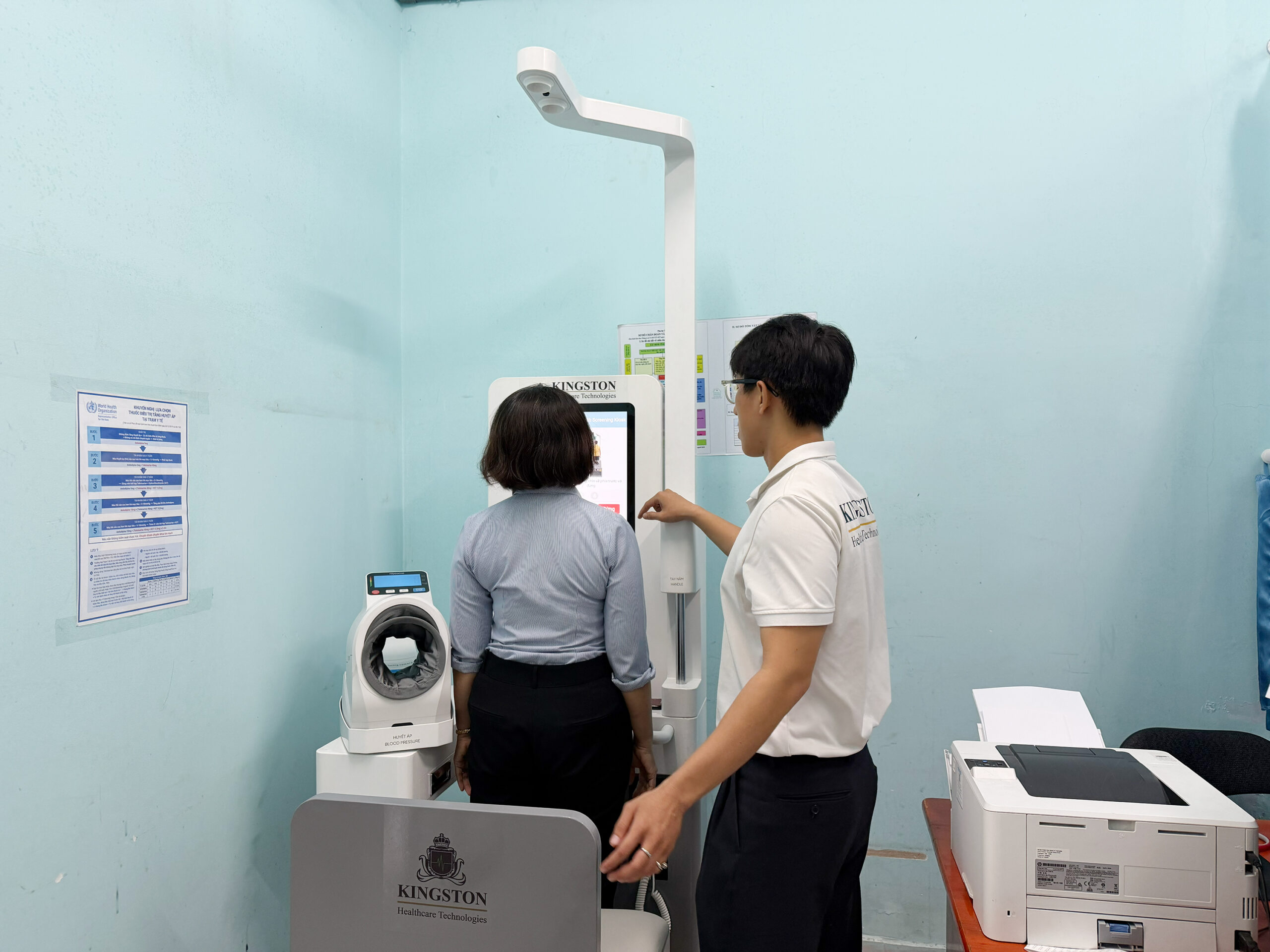 Nhân viên Kingston hướng dẫn người dân đo các chỉ số sức khỏe trên Medi-Kiosk tại xã Hưng Long